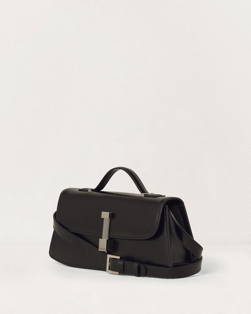 Kassandre Colonne clutch in black cow leather with silver hardware, rigorous lines, adjustable removable strap,crossbody bag, three quarter view