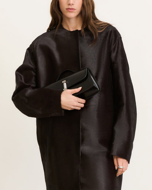 Kassandre Colonne clutch in black cow leather with silver hardware, rigorous lines, worn view