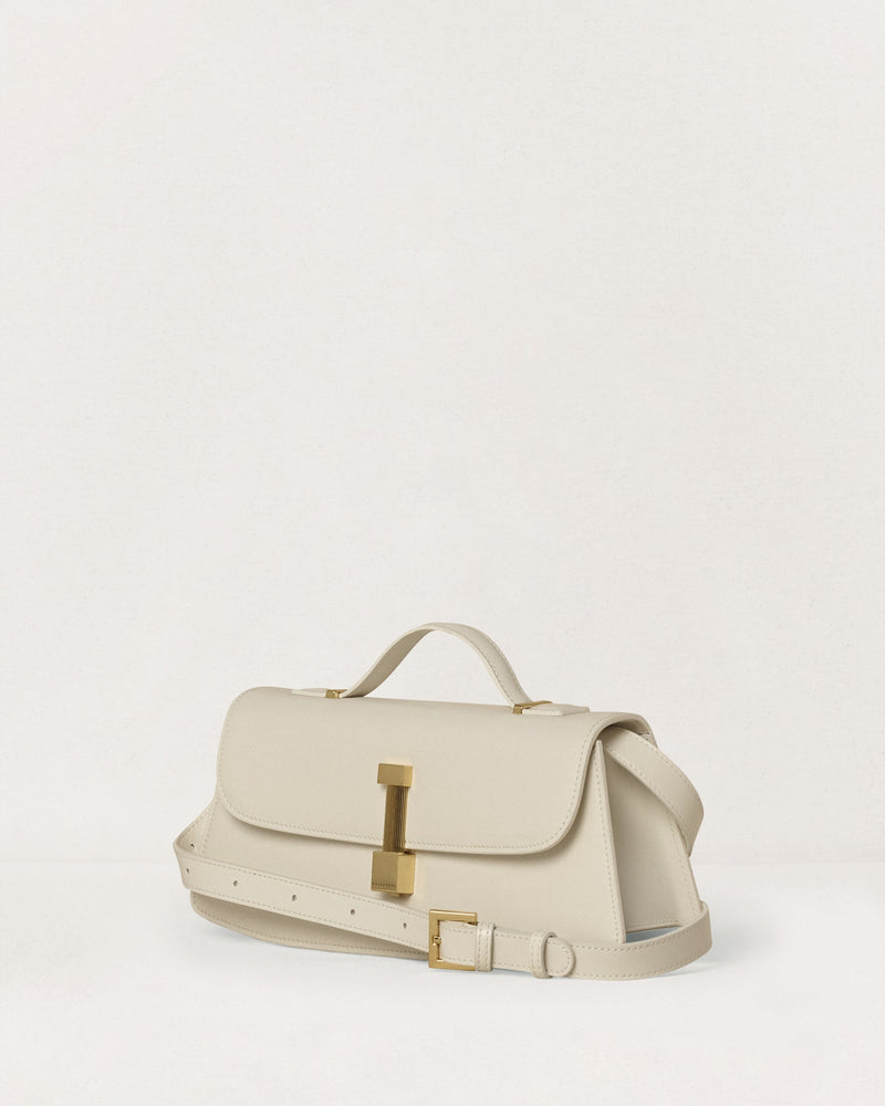 Kassandre Colonne clutch in off-white cow leather with gold hardware, rigorous lines, adjustable removable strap ,crossbody bag, three quarter view