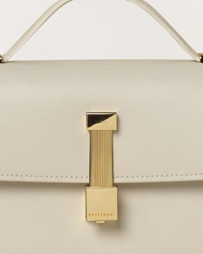Kassandre Colonne clutch in off-white cow leather with gold hardware, rigorous lines, detail view
