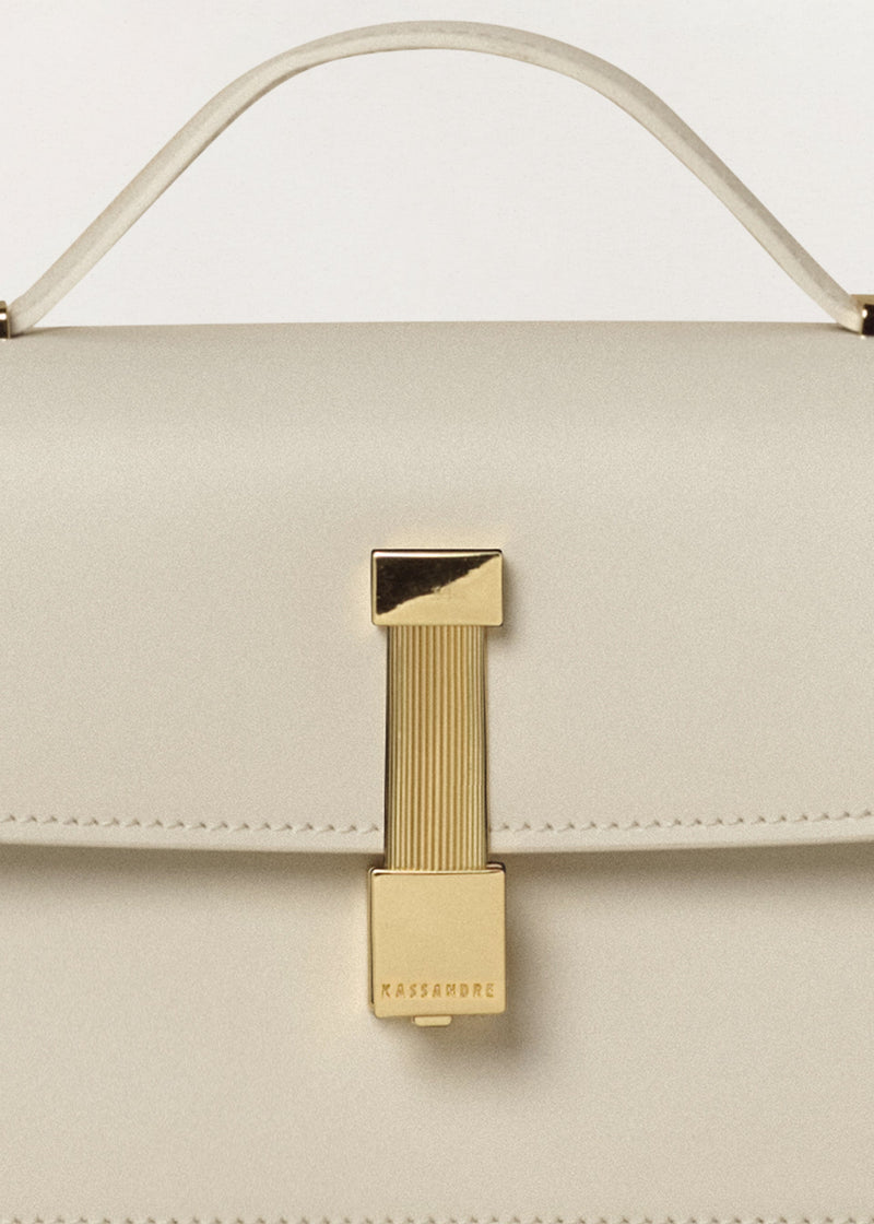 Kassandre Colonne clutch in off-white cow leather with gold hardware, rigorous lines, detail view