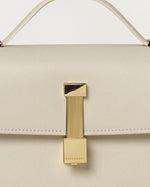 Kassandre Colonne clutch in off-white cow leather with gold hardware, rigorous lines, detail view