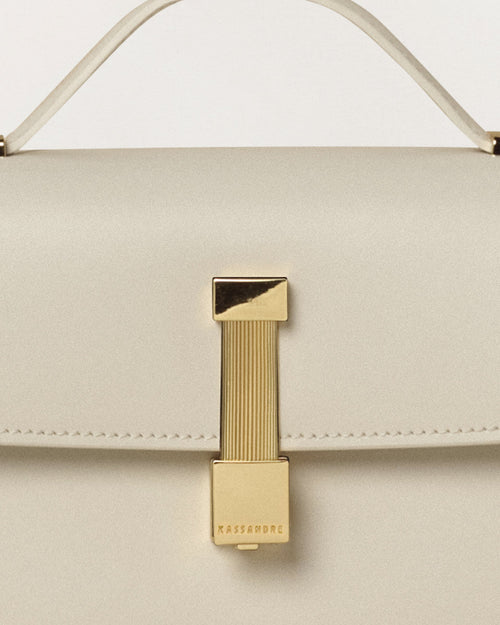Kassandre Colonne clutch in off-white cow leather with gold hardware, rigorous lines, detail view