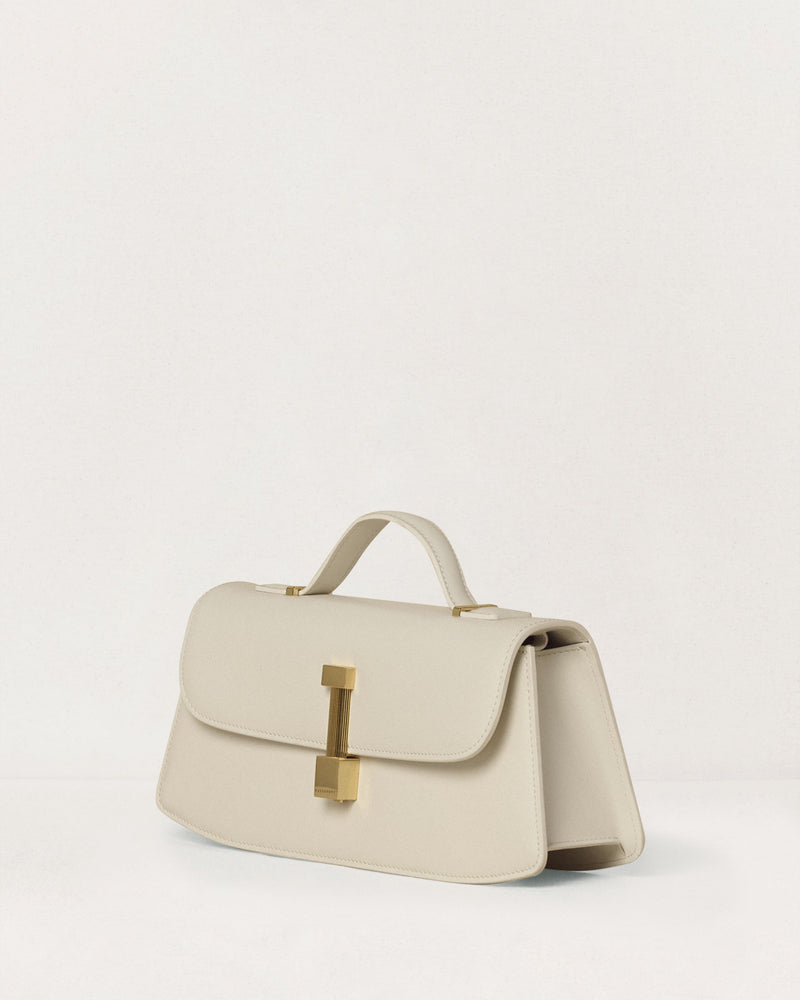 Kassandre Colonne clutch in off-white cow leather with gold hardware, rigorous lines, three quarter view