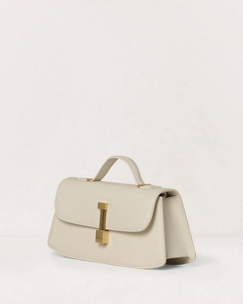 Kassandre Colonne clutch in off-white cow leather with gold hardware, rigorous lines, three quarter view