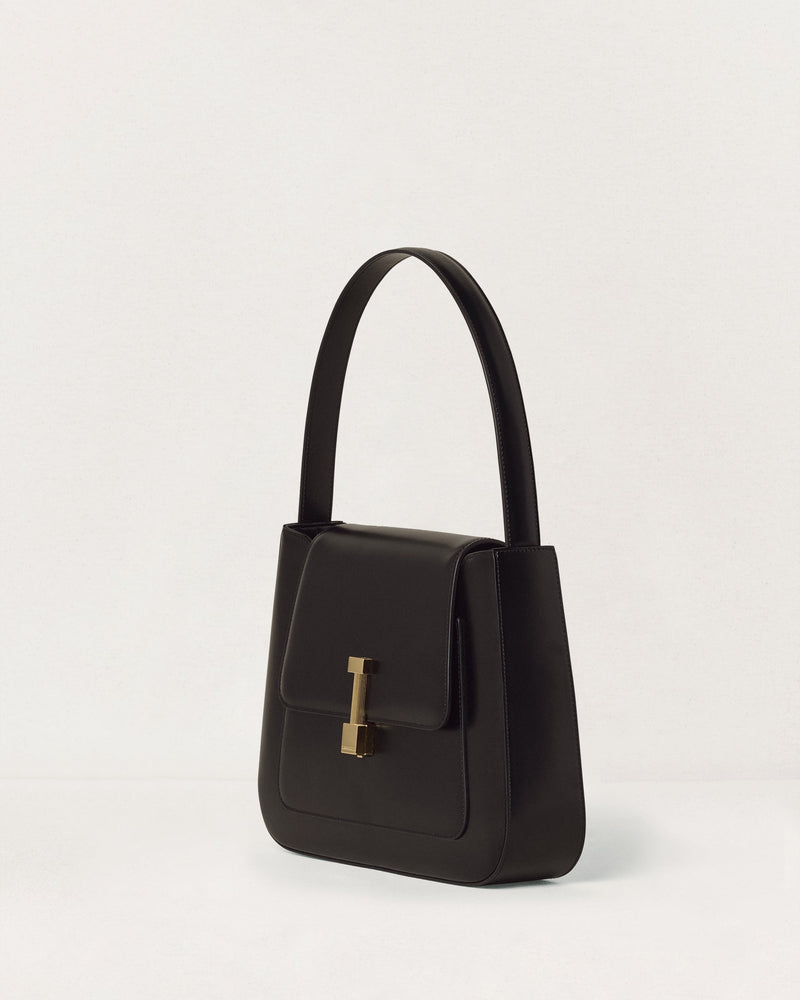 Kassandre Colonne hobo bag in black cow leather with gold hardware, column volume, three quarter view