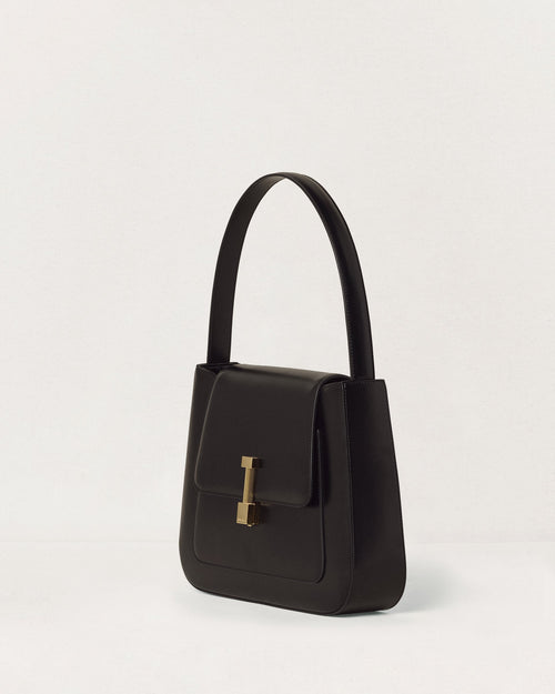Kassandre Colonne hobo bag in black cow leather with gold hardware, column volume, three quarter view