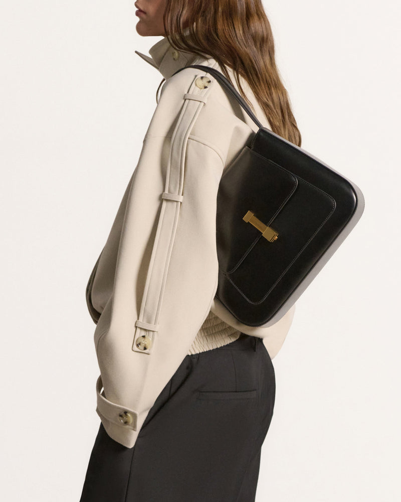 Kassandre Colonne hobo bag in black cow leather with gold hardware, column volume, worn side view