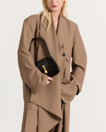 Kassandre Colonne mini hobo bag in black cow leather, column-like volume, worn view