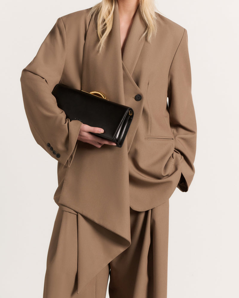 Kassandre Deva clutch in black cow leather with gold hardware, Art Deco geometry,removable strap , crossbody bag , worn view