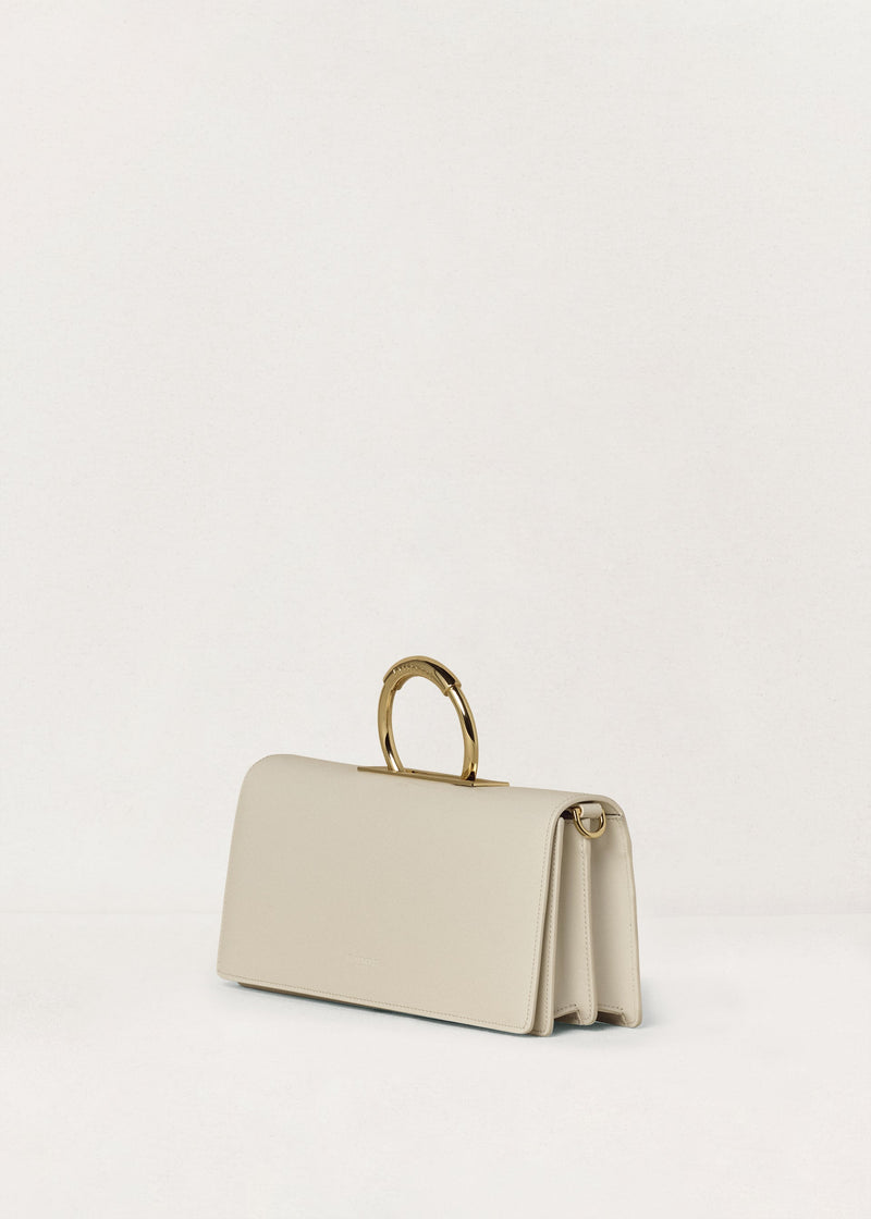 Kassandre Deva clutch in off-white cow leather, pure geometric form, adjustable strap, removable strap , crossbody bag ,three quarter view
