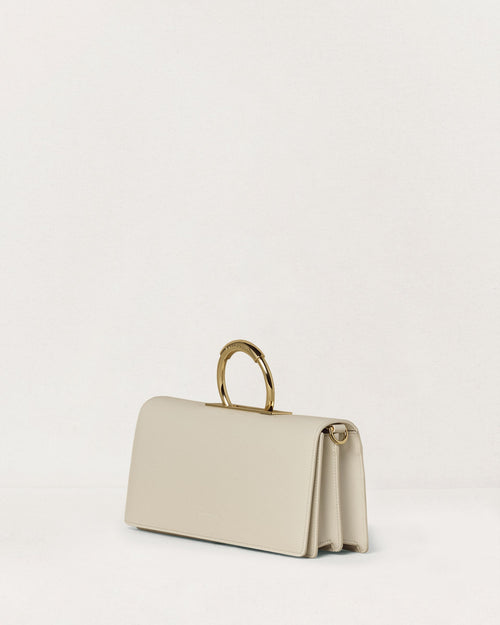 Kassandre Deva clutch in off-white cow leather, pure geometric form, adjustable strap, removable strap , crossbody bag ,three quarter view