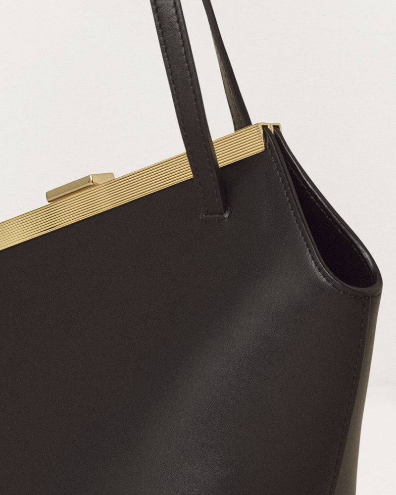 Kassandre Eileen asymmetric shoulder bag in black cow leather, architectural line, gold frame,detail view