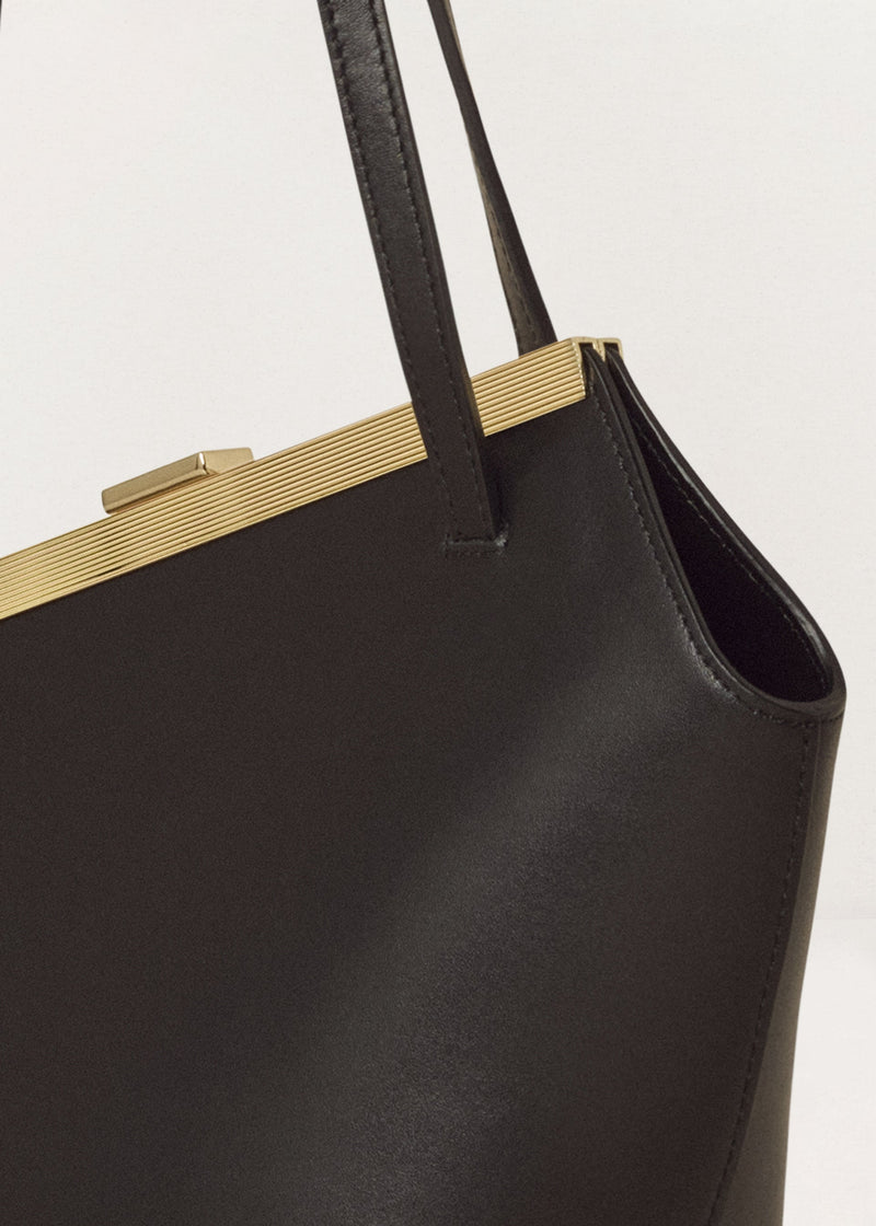 Kassandre Eileen asymmetric shoulder bag in black cow leather, architectural line, gold frame,detail view