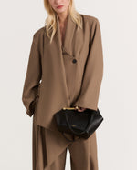 Kassandre Eileen asymmetric shoulder bag in black cow leather, architectural line, gold frame,worn view