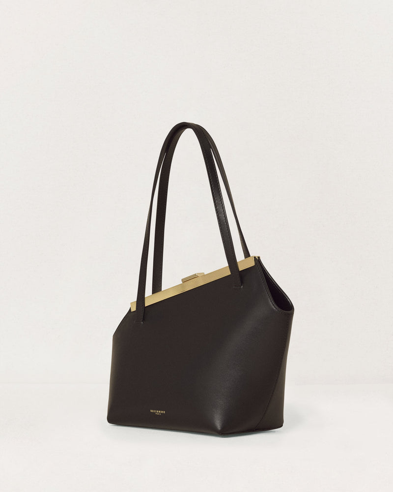 Kassandre Eileen asymmetric shoulder bag in black cow leather, architectural line, gold frame,three quarter view