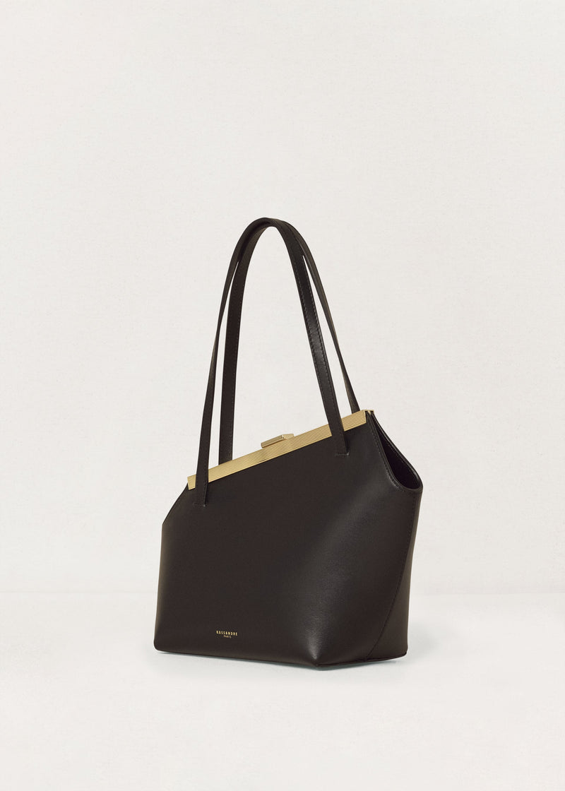 Kassandre Eileen asymmetric shoulder bag in black cow leather, architectural line, gold frame,three quarter view
