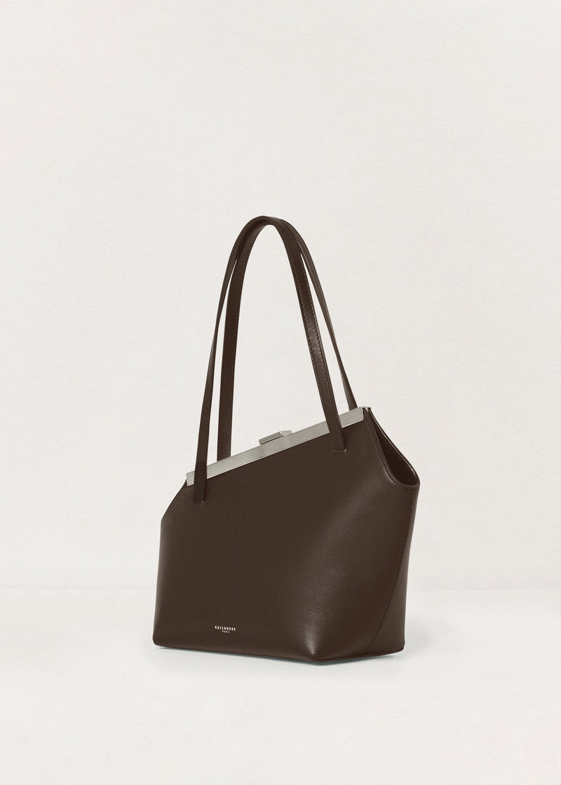 Kassandre Eileen asymmetric shoulder bag in brown cow leather, silver frame, graphic geometry, three quarter view 
