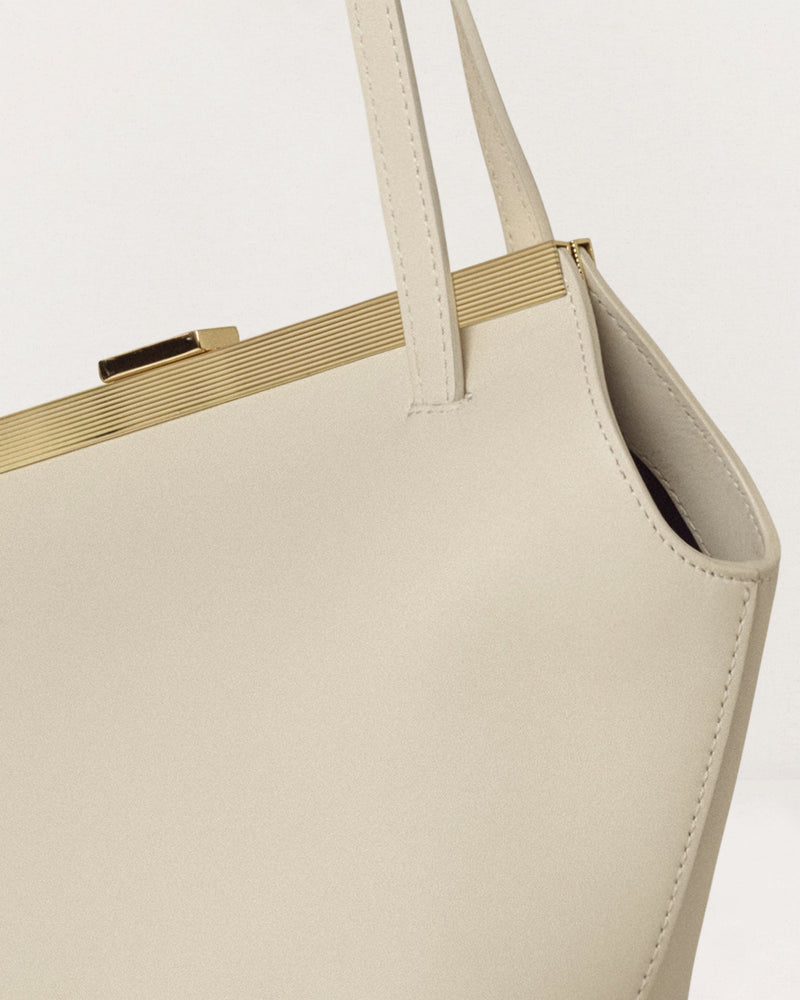 Kassandre Eileen asymmetric shoulder bag in off-white cow leather, clean line, gold frame, detail view