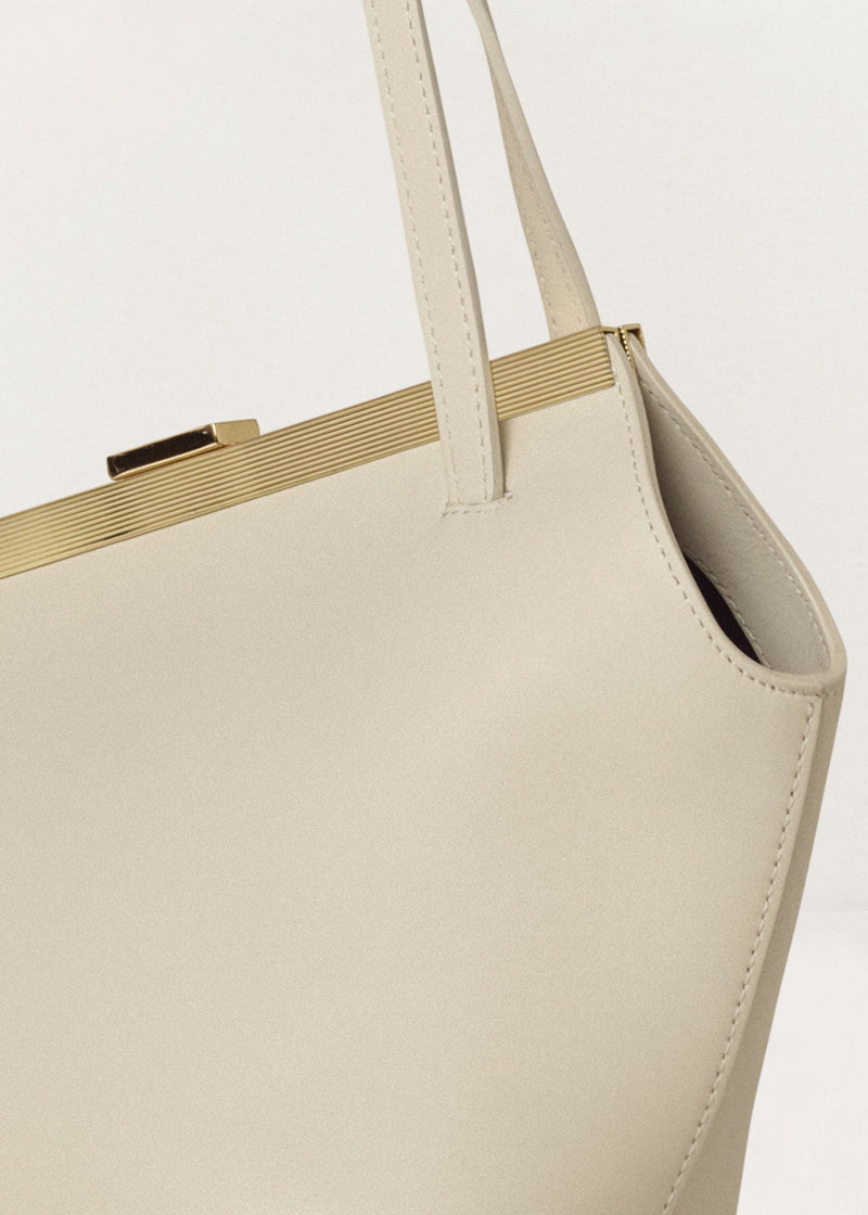 Kassandre Eileen asymmetric shoulder bag in off-white cow leather, clean line, gold frame, detail view