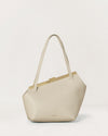 Kassandre Eileen asymmetric shoulder bag in off-white cow leather, clean line, gold frame, front view
