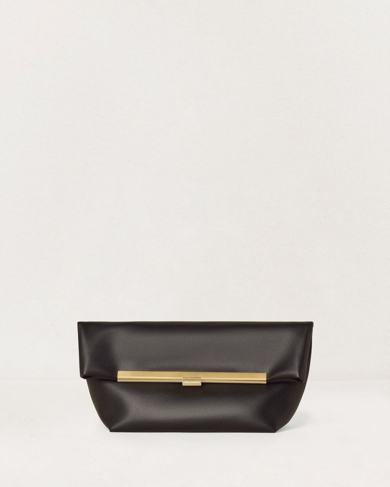 Kassandre Eileen clutch in black cow leather with gold striped metal frame and engraved clasp front view