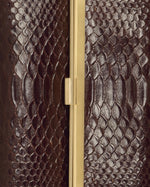 Kassandre Eileen clutch in brown python-effect leather with striped metal frame, detail view