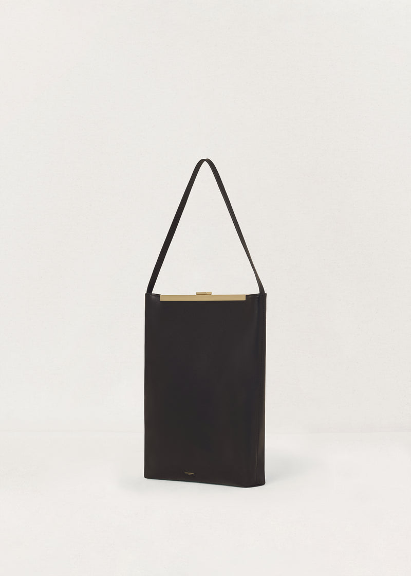 Kassandre Eileen computer bag in black cow leather with gold striped metal frame, three quarter view