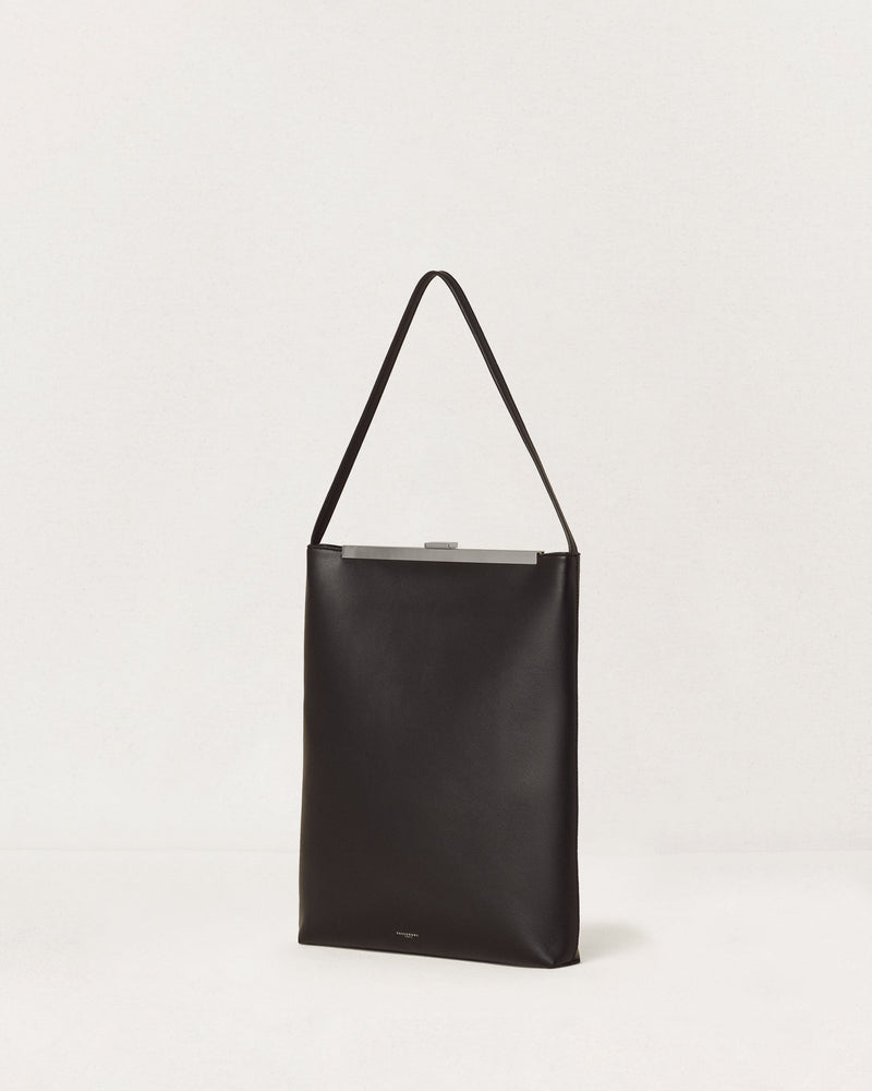 Kassandre Eileen computer bag in black cow leather with silver striped metal frame,three quarter view
