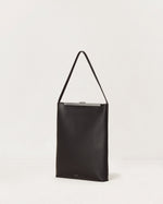 Kassandre Eileen computer bag in black cow leather with silver striped metal frame,three quarter view
