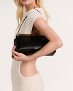 Kassandre Eileen shoulder bag in black smooth cow leather with striped metal frame, side view