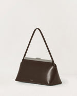 Kassandre Eileen shoulder bag in brown smooth cow leather with striped metal frame, three quarter view