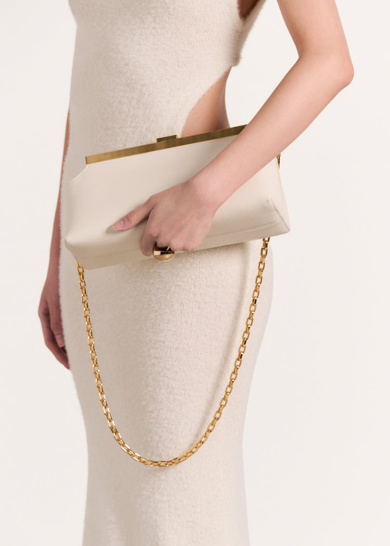 Kassandre Eileen shoulder bag in off-white cow leather with gold striped metal frame, worn view